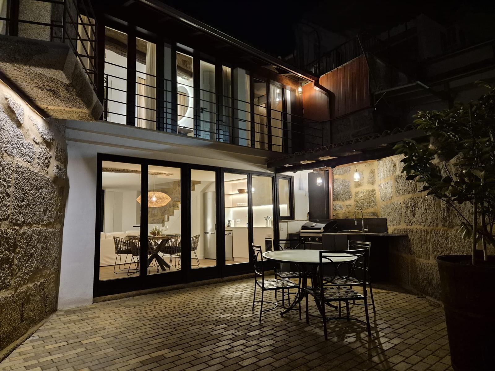 terraza amplia de noche con barbacoa para alquiler vacacional