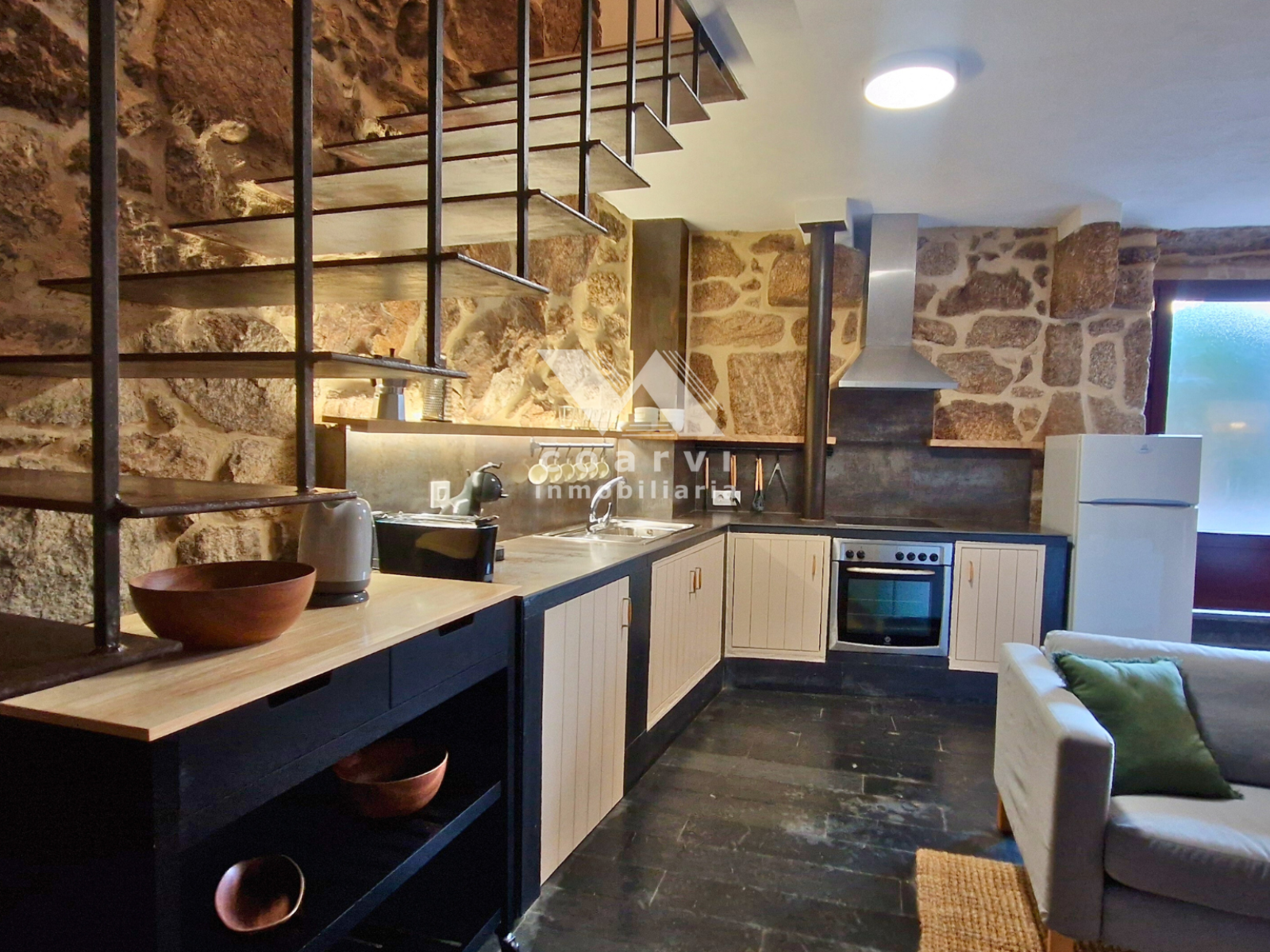 Cocina abierta con paredes de piedra de casa en Parada de Ventosa